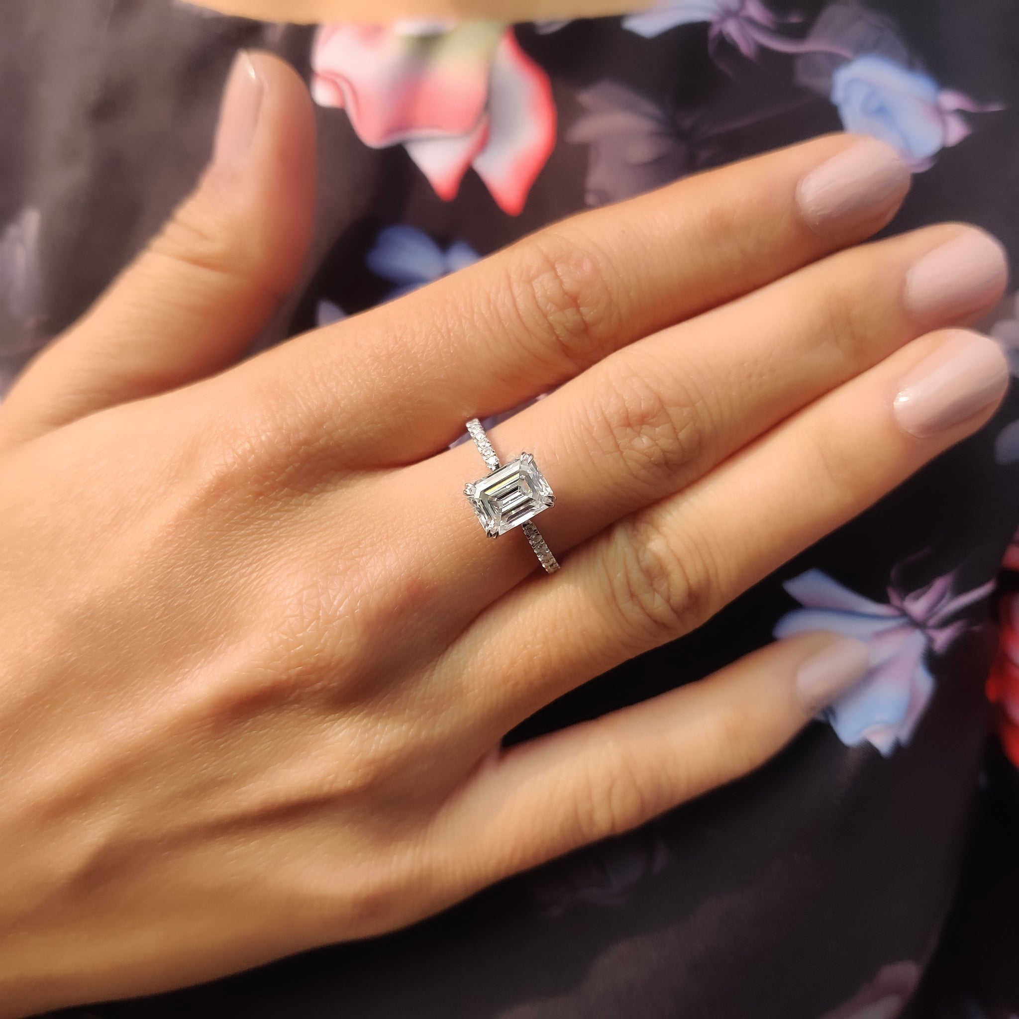 Double claw prong engagement ring in white gold with emerald cut stone.
