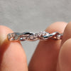 Moissanite wedding band with a twisted gold setting for added sparkle.