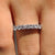 Round moissanite wedding band with a sleek half eternity design in white gold.