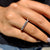 Round wedding band with a half eternity design and round moissanite stones.