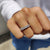 Oval wedding band featuring sleek moissanite stones set in a continuous eternity layout.