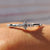 Round cut wedding band featuring prong set moissanite for a clean and modern look.