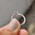 Gold proposal ring featuring a round cut moissanite.
