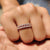 Classic wedding band resting on a velvet fabric surface.

