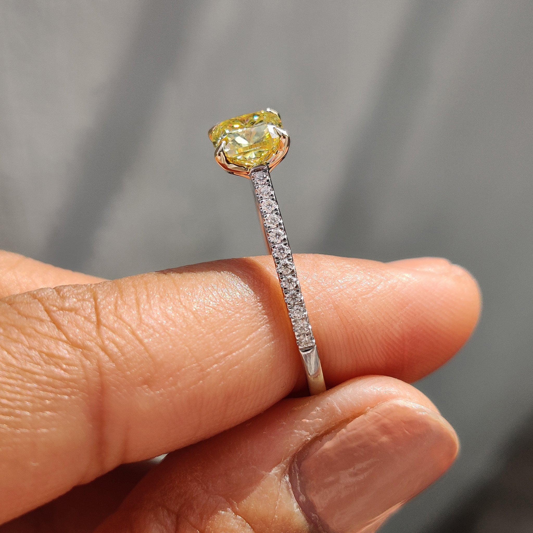 Claw prong setting highlighting the brilliance of a canary yellow stone ring in a two-tone gold design.
