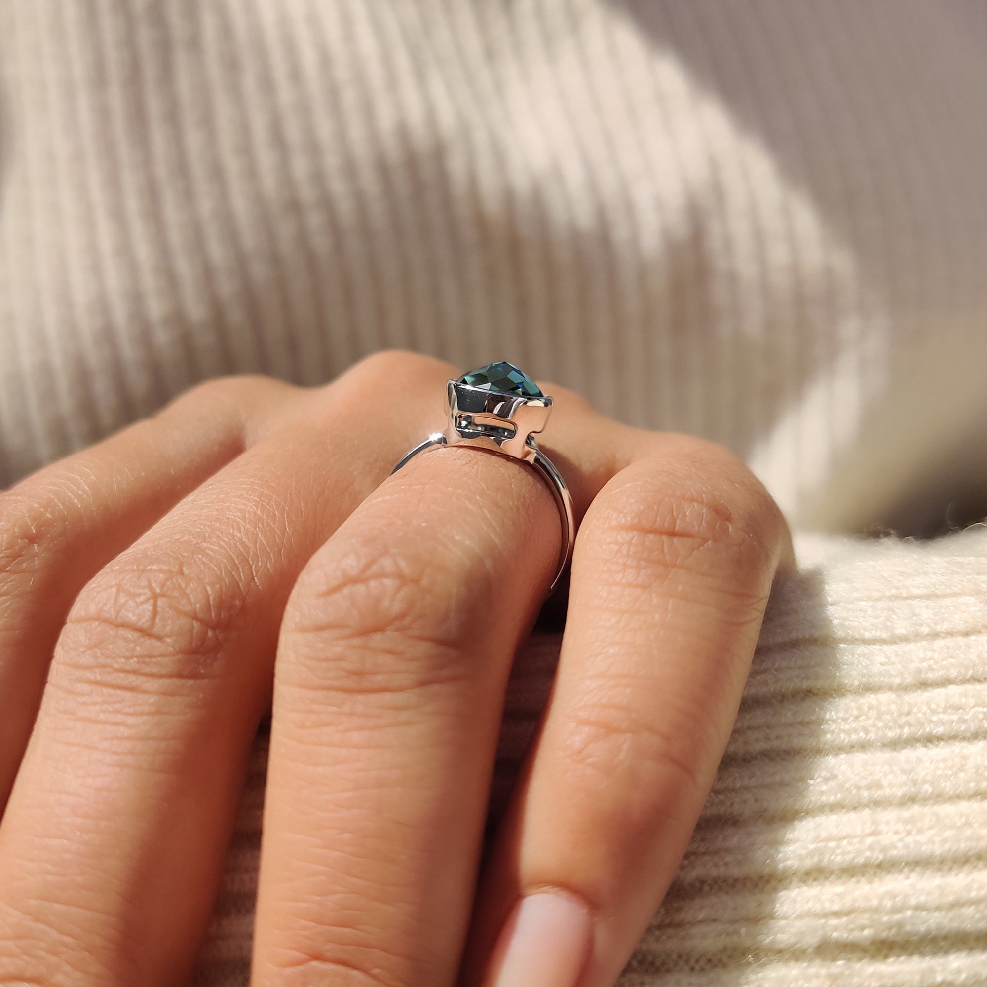 Bezel setting solitaire ring with a green round rose cut Moissanite in white gold.
