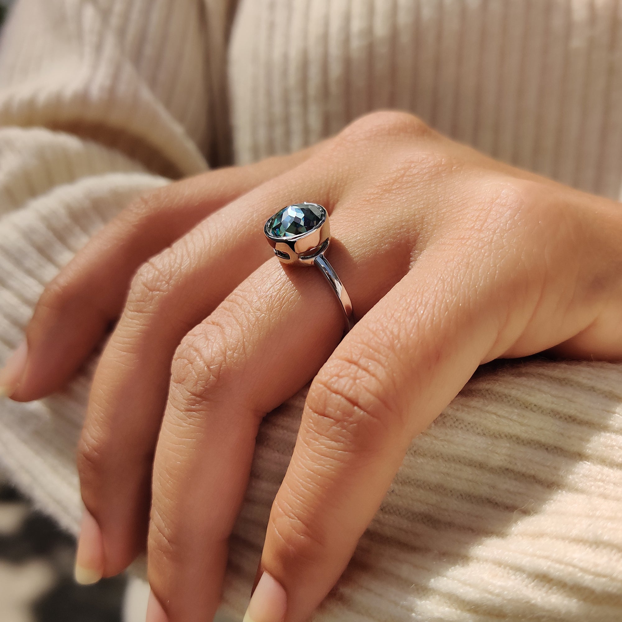 Moissanite engagement ring featuring a green round rose cut stone in a minimalist solitaire style.
