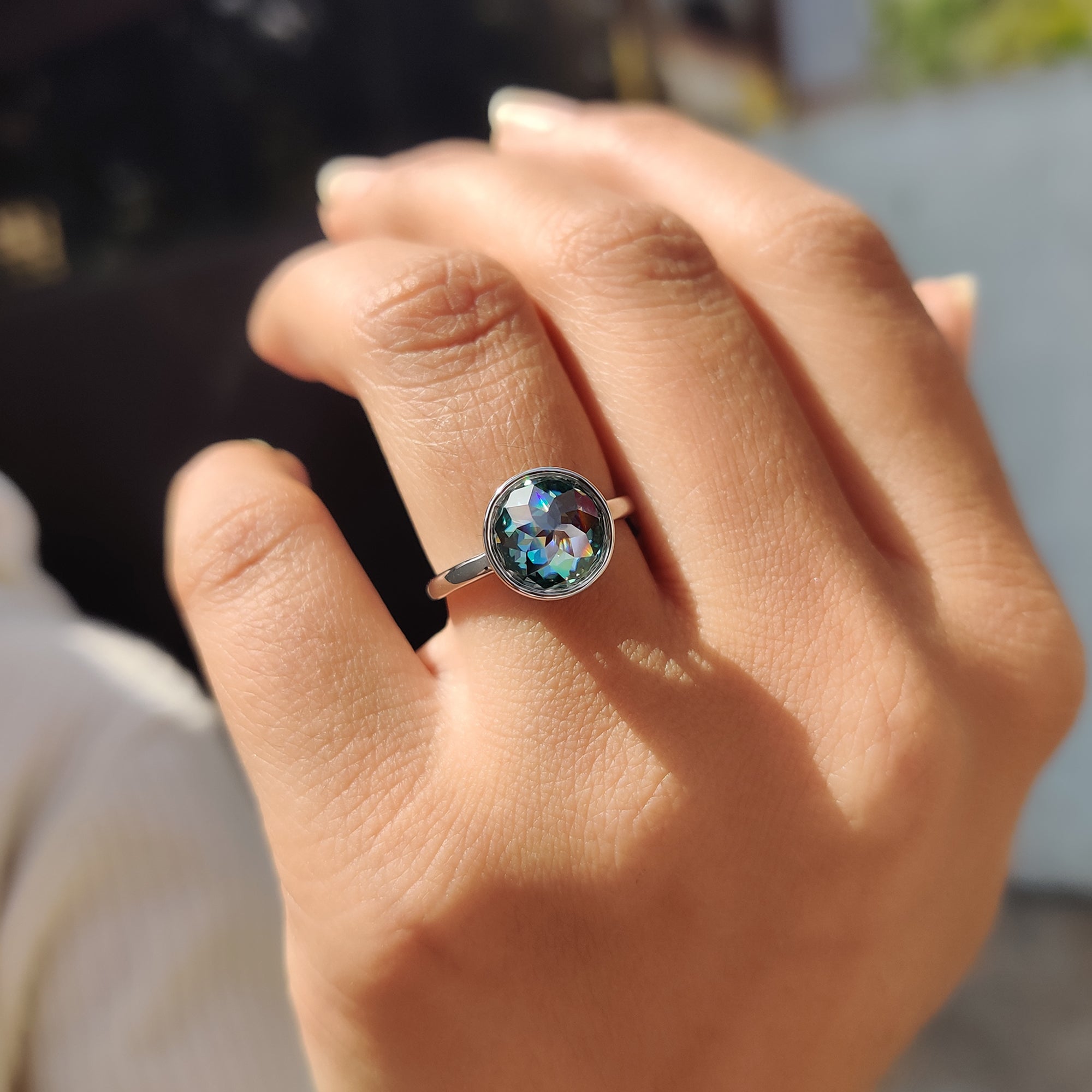 Women’s anniversary ring with a custom green round Moissanite rose cut stone in a bezel setting.
