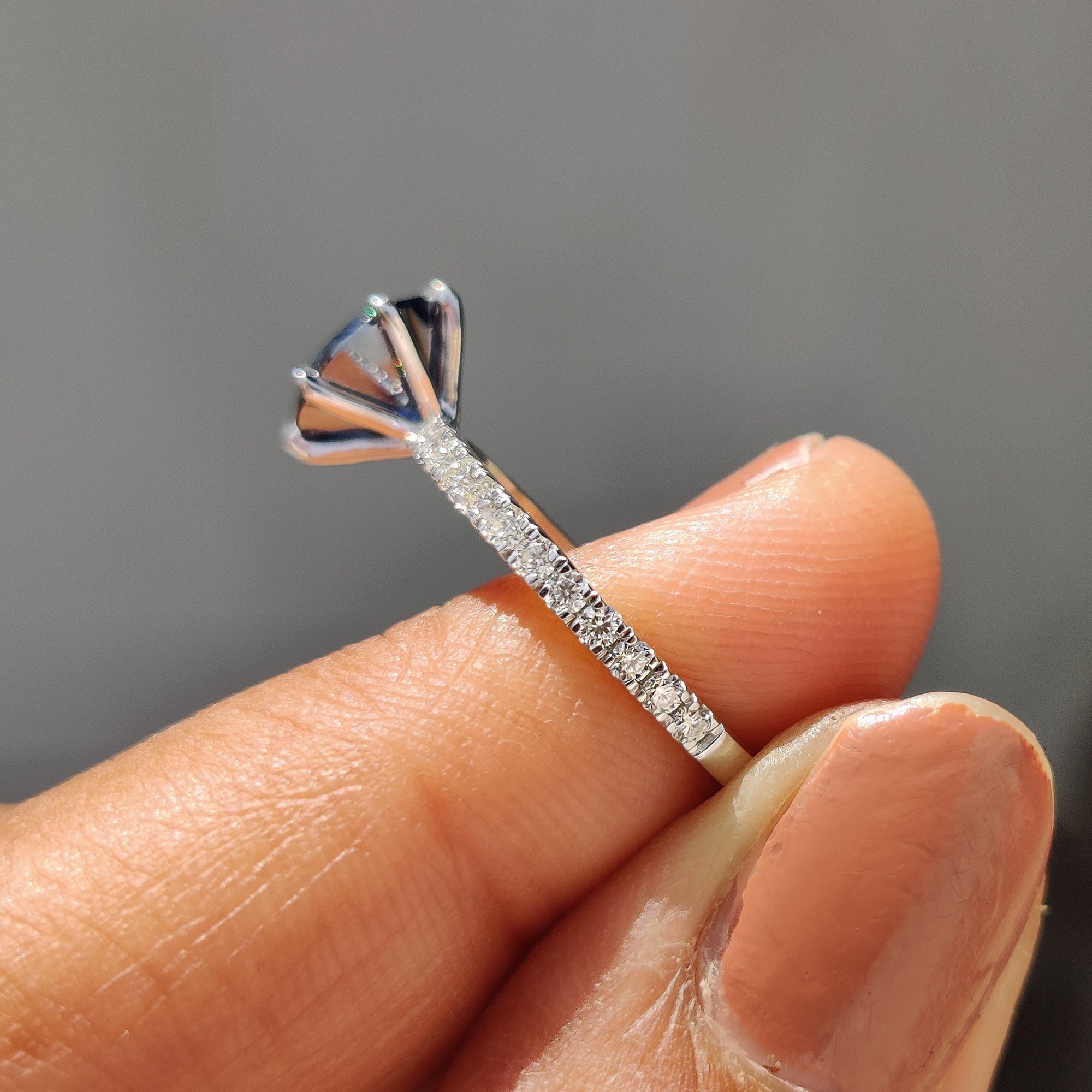 Moissanite engagement ring in white gold with a round pave band and stunning blue centre stone.
