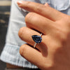 3 claw prong setting on a white gold pear-shaped engagement ring with royal dark blue Moissanite.
