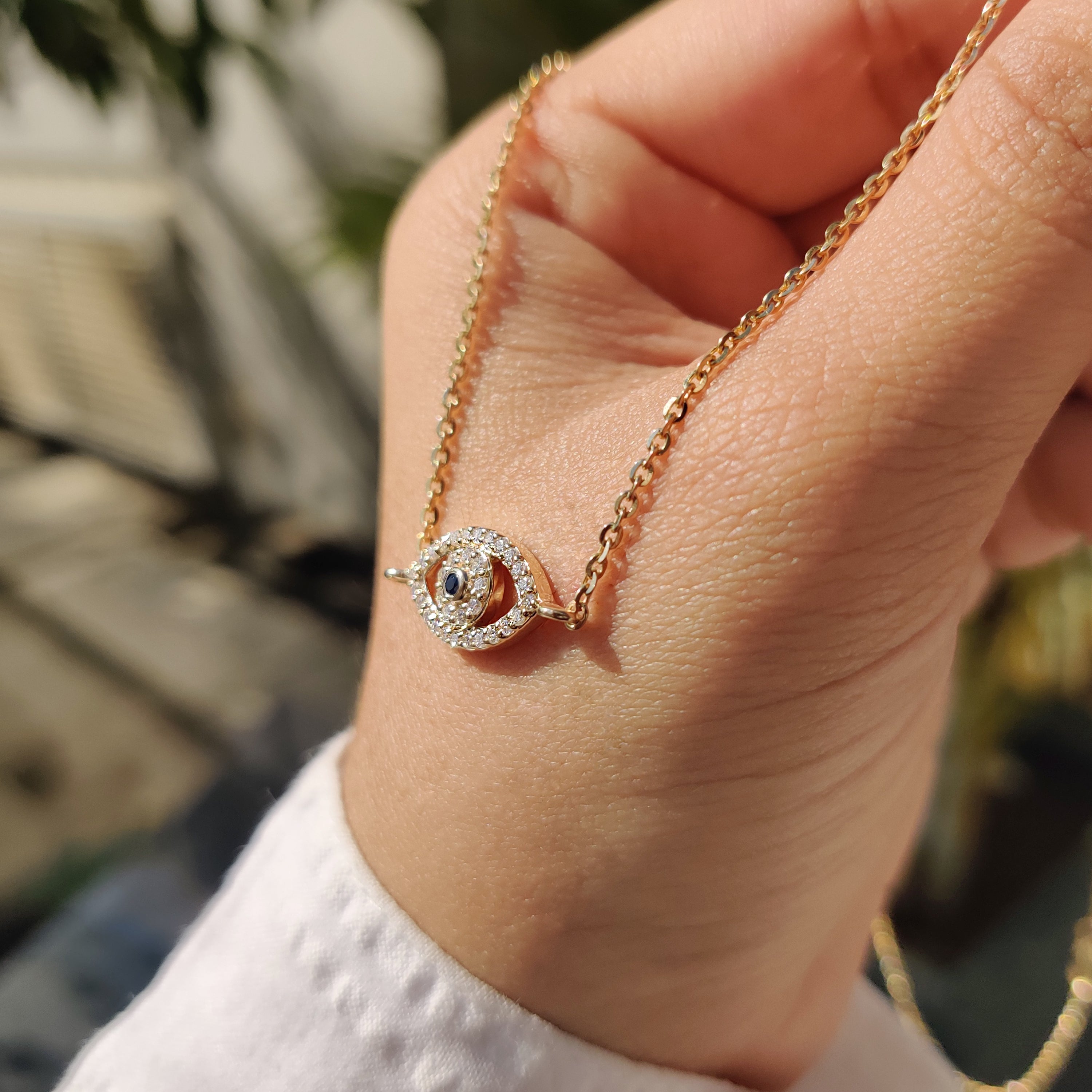 Eye-shaped pendant with a lab-grown diamond at the center.