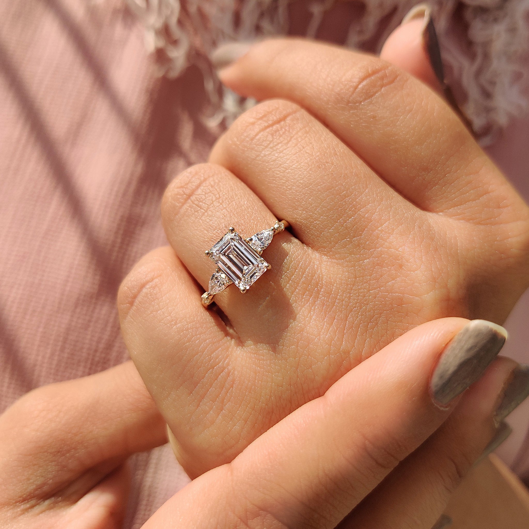 Buy engagement ring with emerald cut diamond and side stones.

