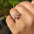 Engagement ring featuring emerald cut center stone with pear and round side stones.
