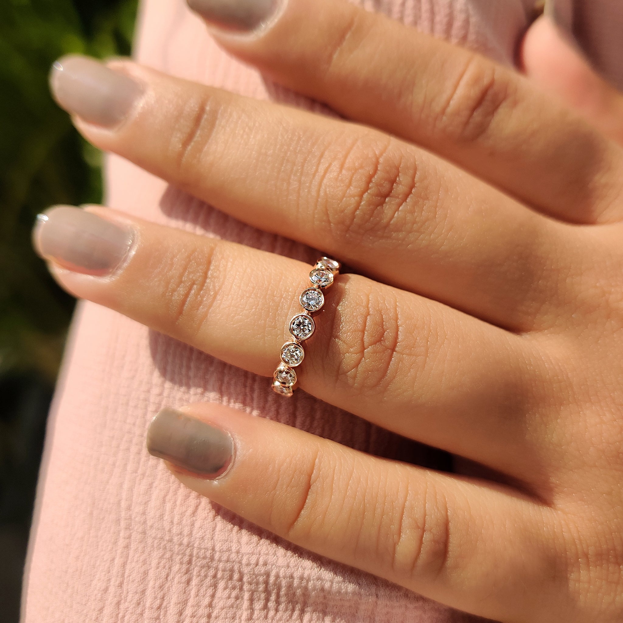 Rose gold band with bezel-set diamonds.
