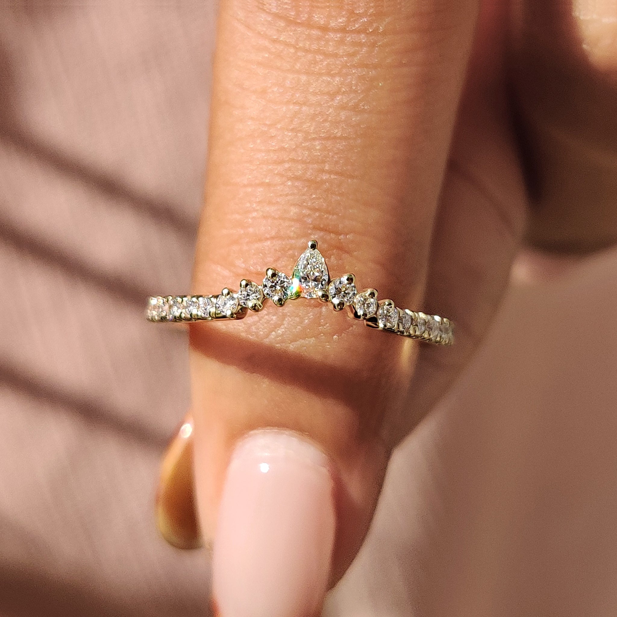 Curved wedding band yellow gold with a smooth shared prong setting.
