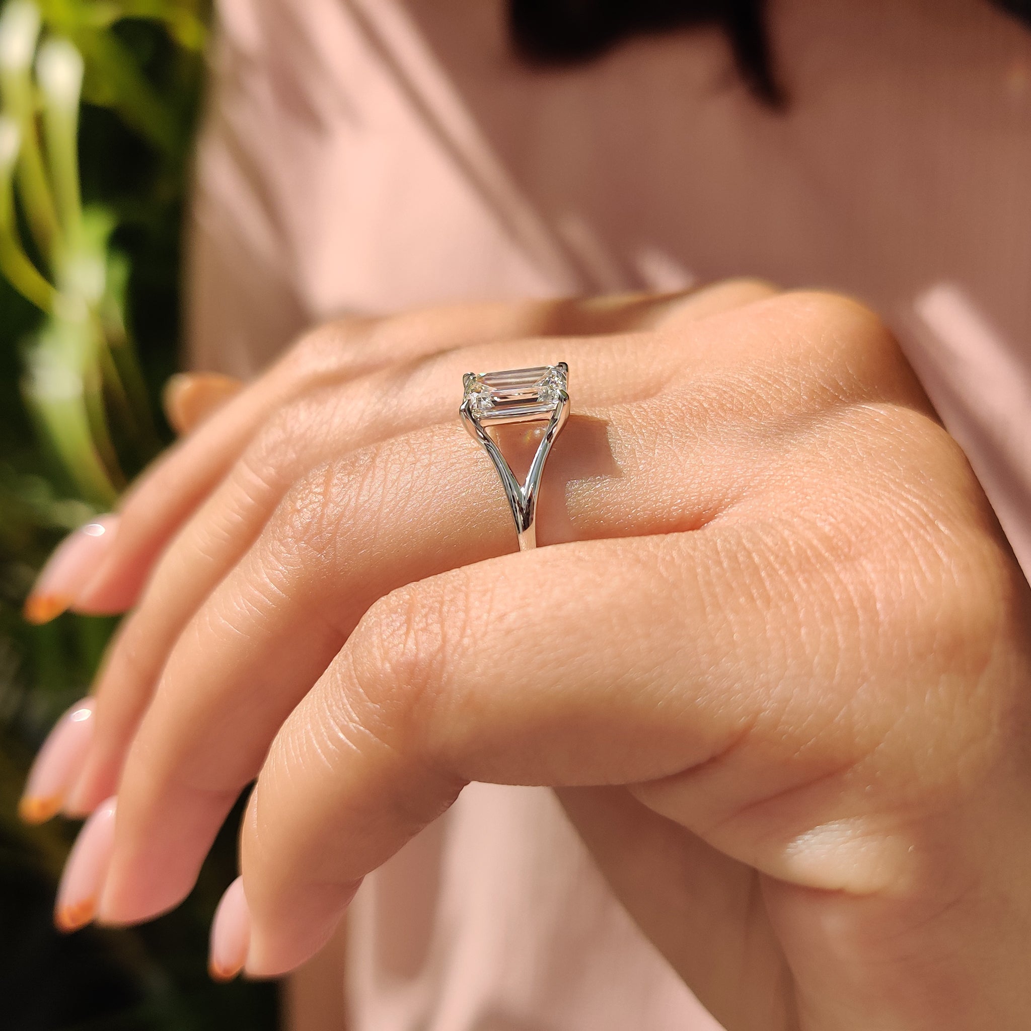 Exquisite four-claw prong ring featuring a sparkling emerald cut diamond, set in a handmade white gold band.
