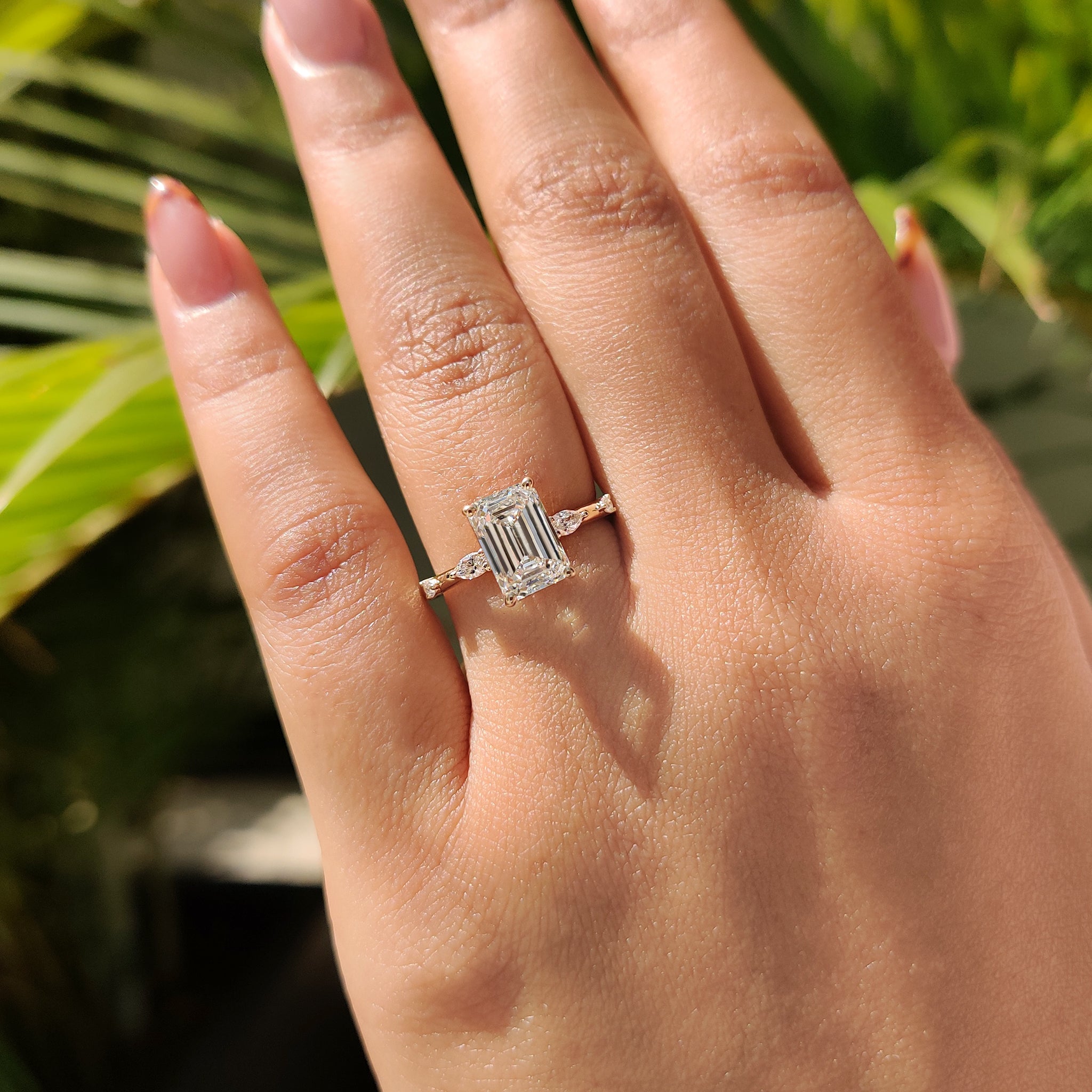 A custom handmade ring featuring stone emerald cut diamond ring and marquise, round cut diamonds set in yellow gold.
