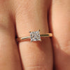 A princess cut solitaire diamond engagement ring set in yellow gold with an elegant cathedral setting.
