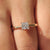 A princess cut solitaire diamond engagement ring set in yellow gold with an elegant cathedral setting.
