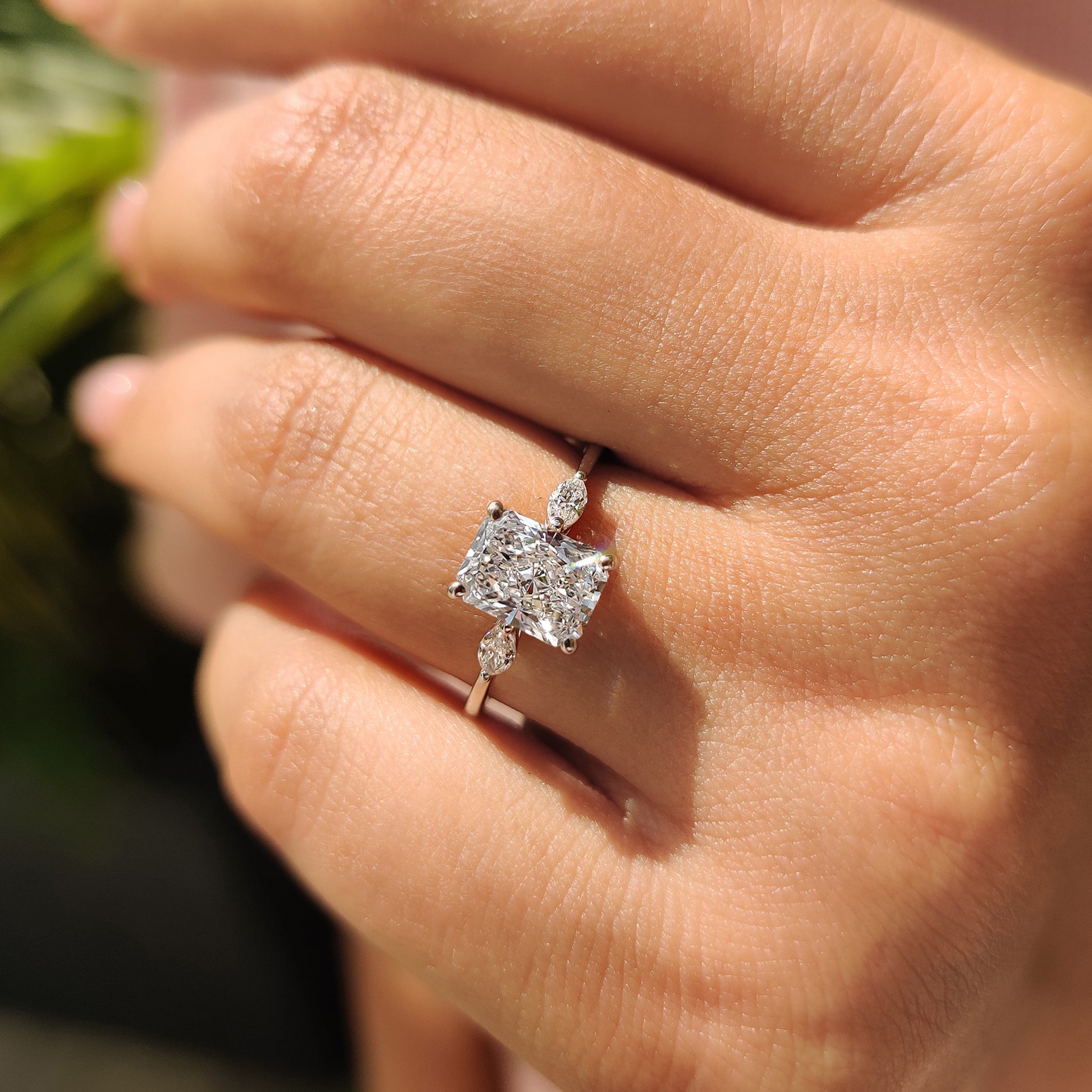Handmade ring with a radiant cut diamond and marquise side stones, set in yellow gold.
