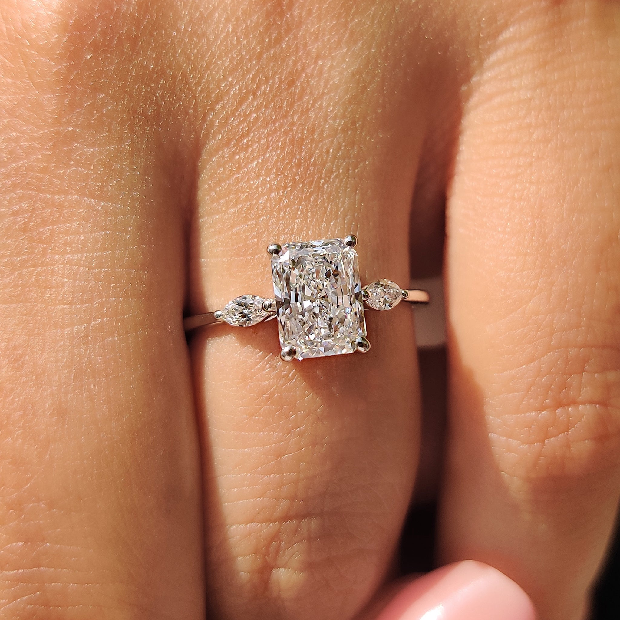 Lab Grown Diamond 3 Stone Ring with radiant cut and marquise side stones in a yellow gold band.
