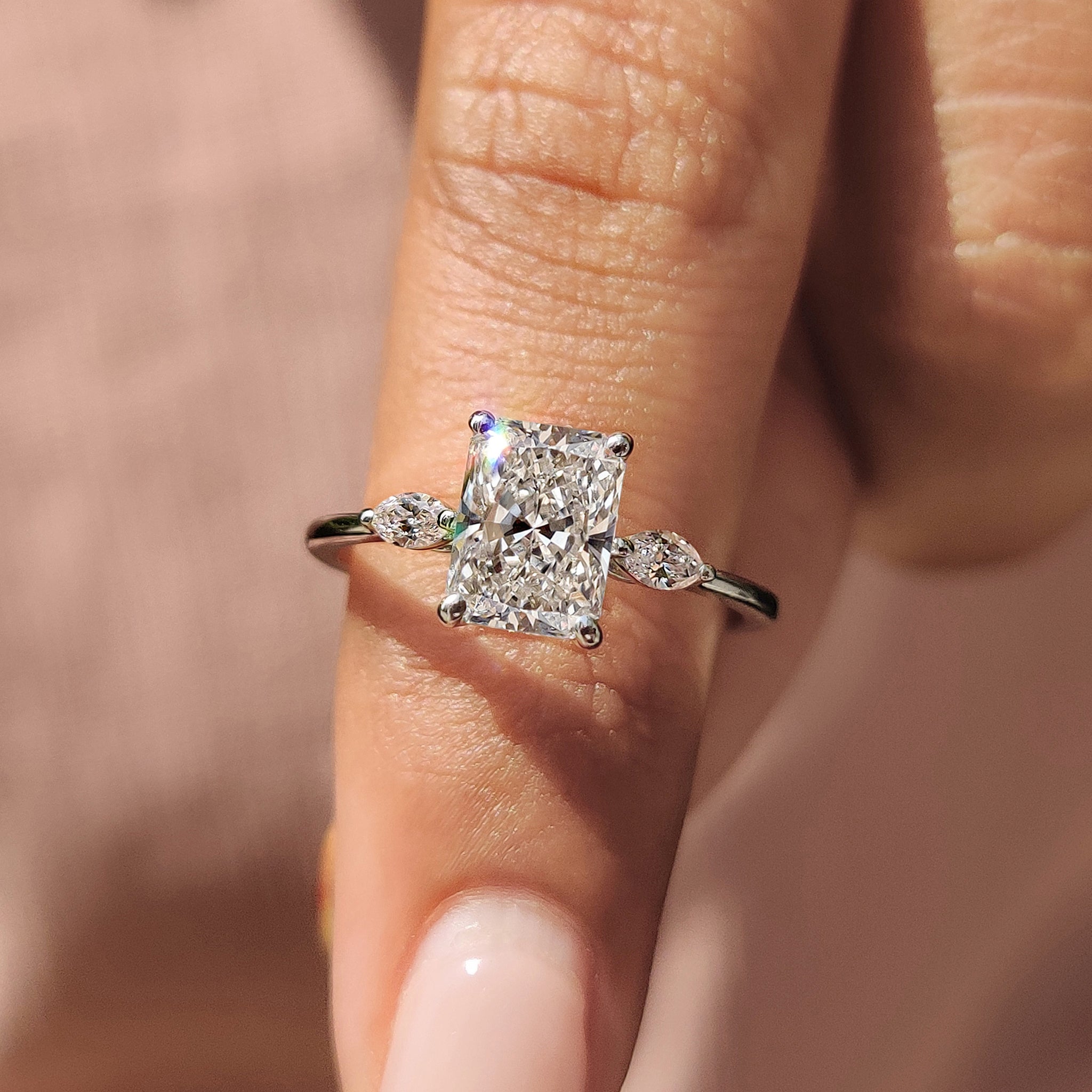 Elegant 4 prong ring setting with radiant cut and marquise side stones in yellow gold.
