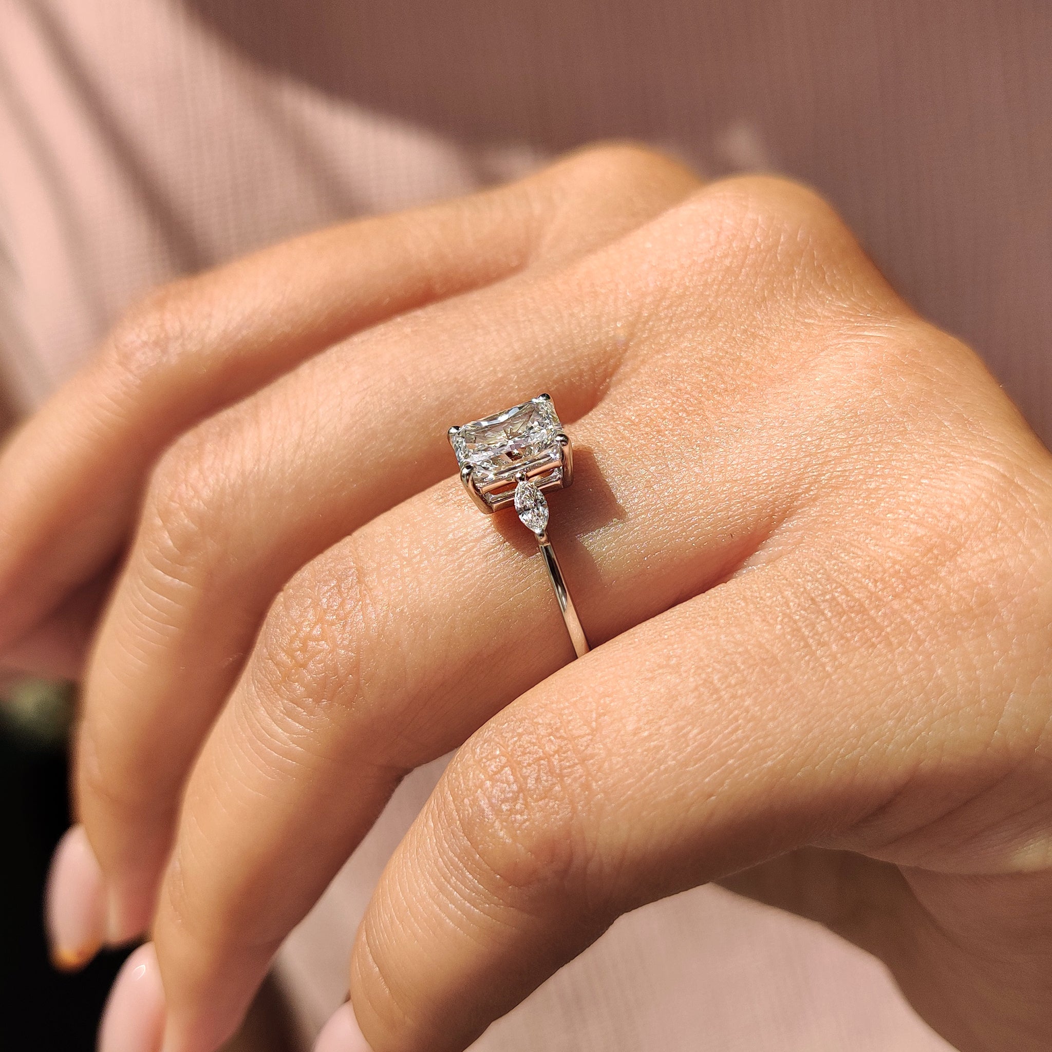 Handmade Jewelry with a radiant cut diamond and marquise side stones in a yellow gold setting.
