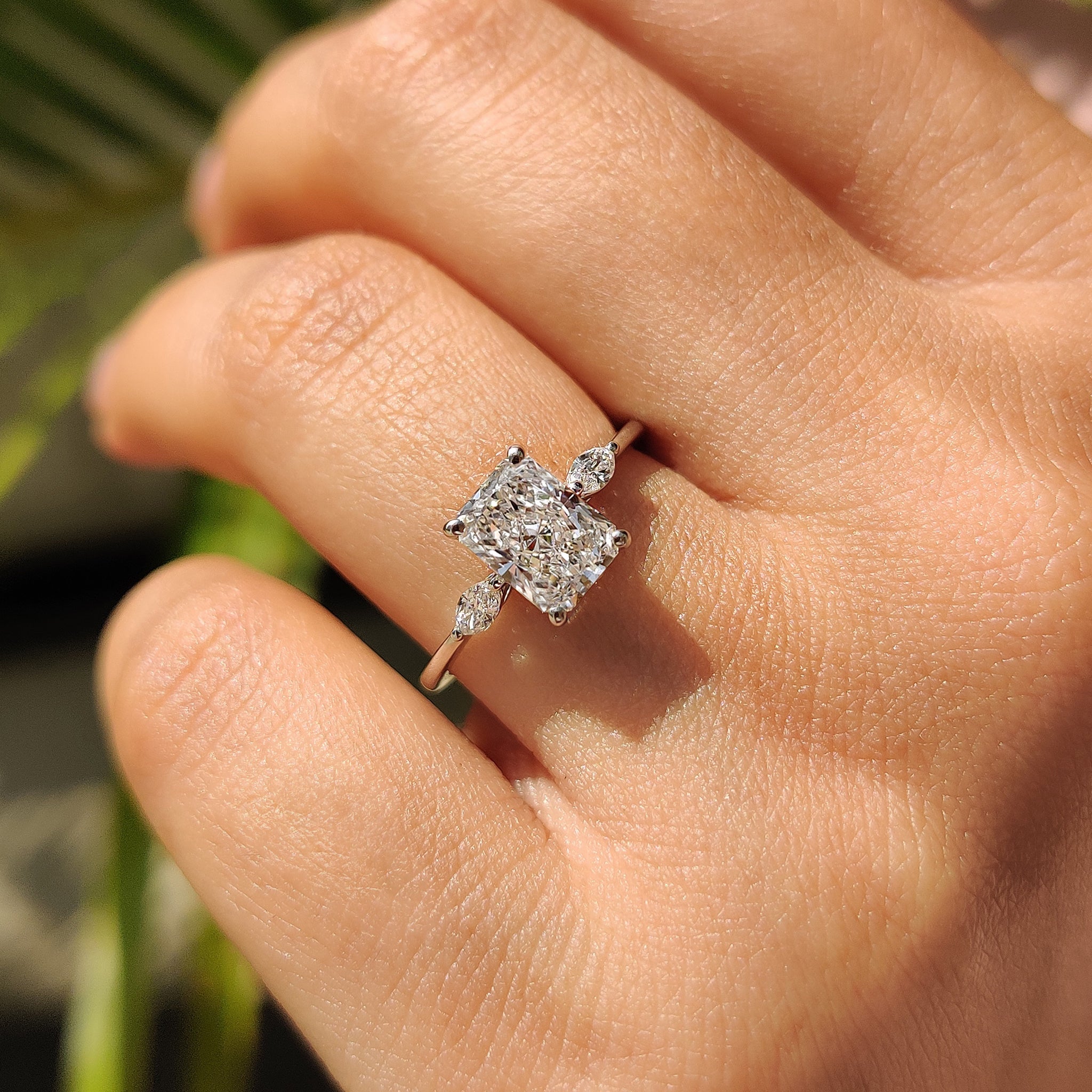 Carat Diamonds Engagement Ring featuring a radiant cut center diamond and marquise side stones.
