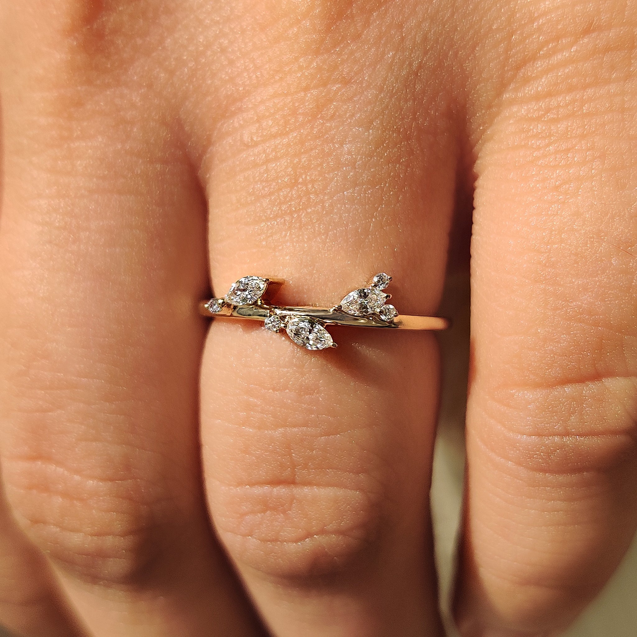 Yellow gold wedding ring with marquise diamond and round diamond side stones.