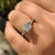 Custom engagement ring with princess diamond center stone and round diamond side stones.