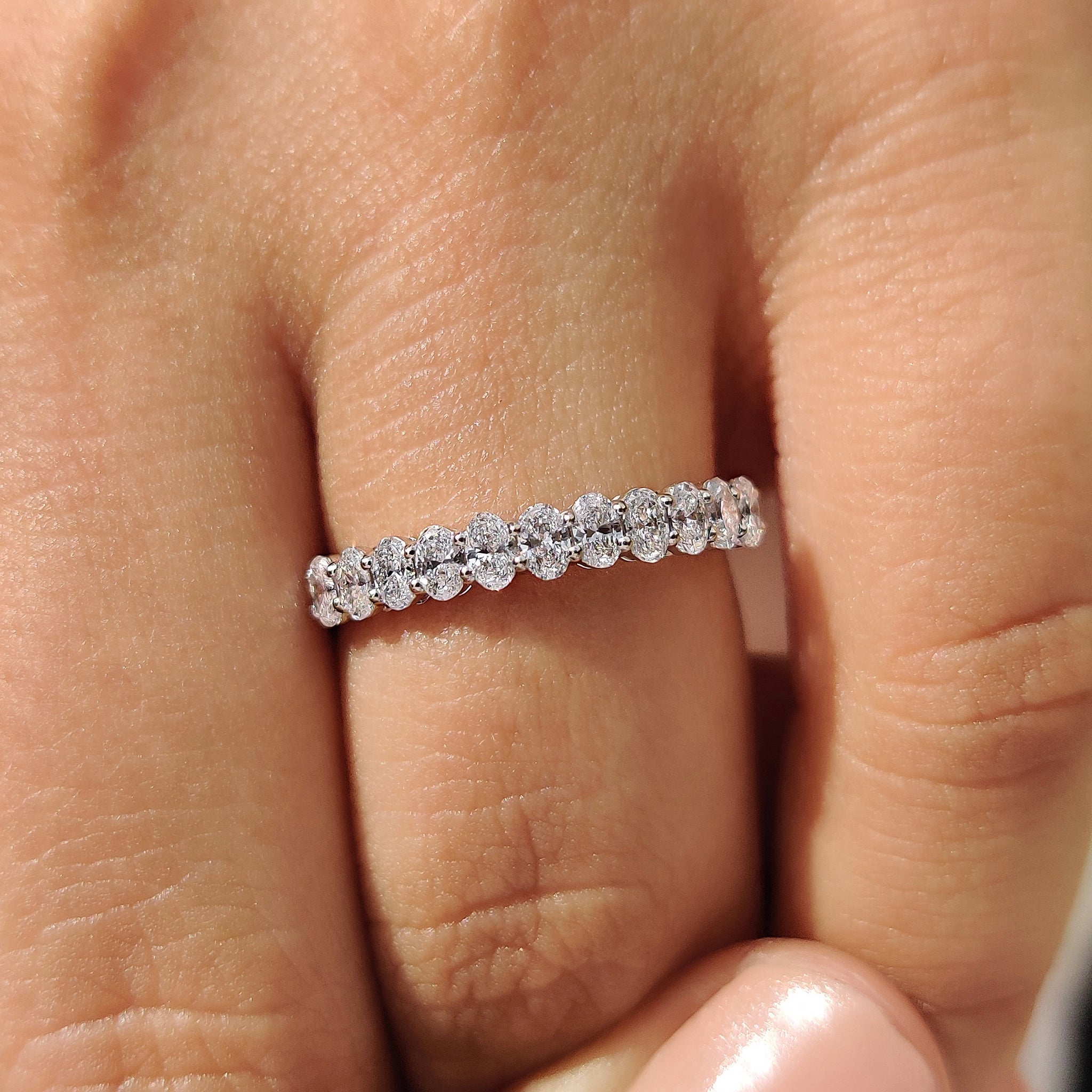 White gold wedding band with oval diamond and semi eternity style.

