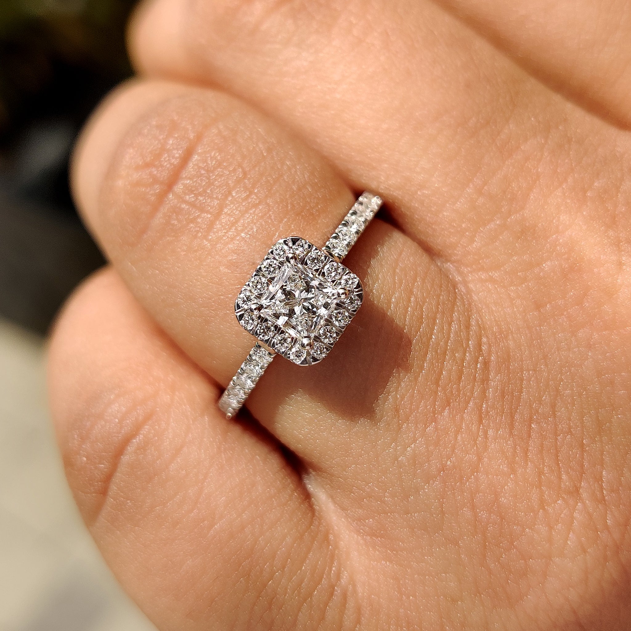 
Round cut side stones in a halo princess cut engagement ring.