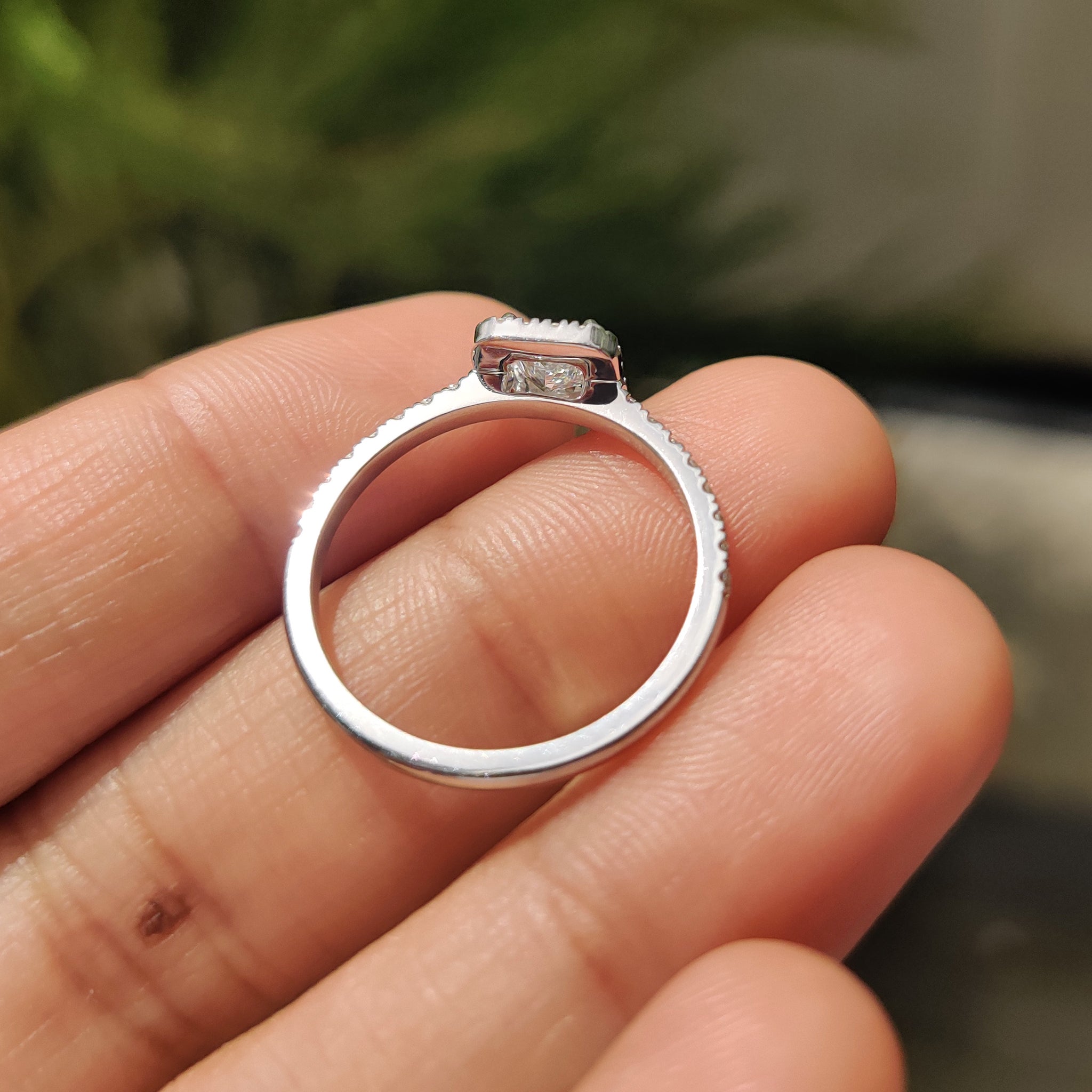 White gold engagement ring with cathedral setting and round side stones.
