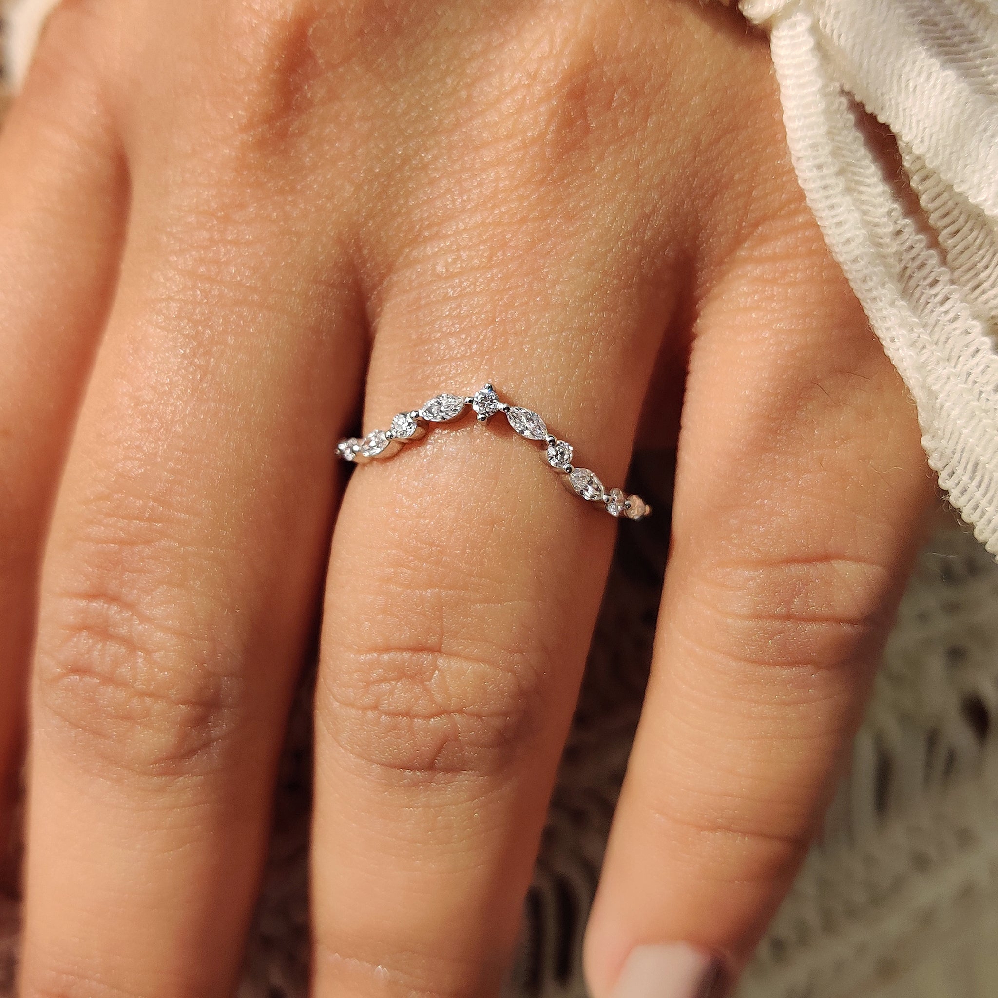 Curvy wedding band with shared prong style.