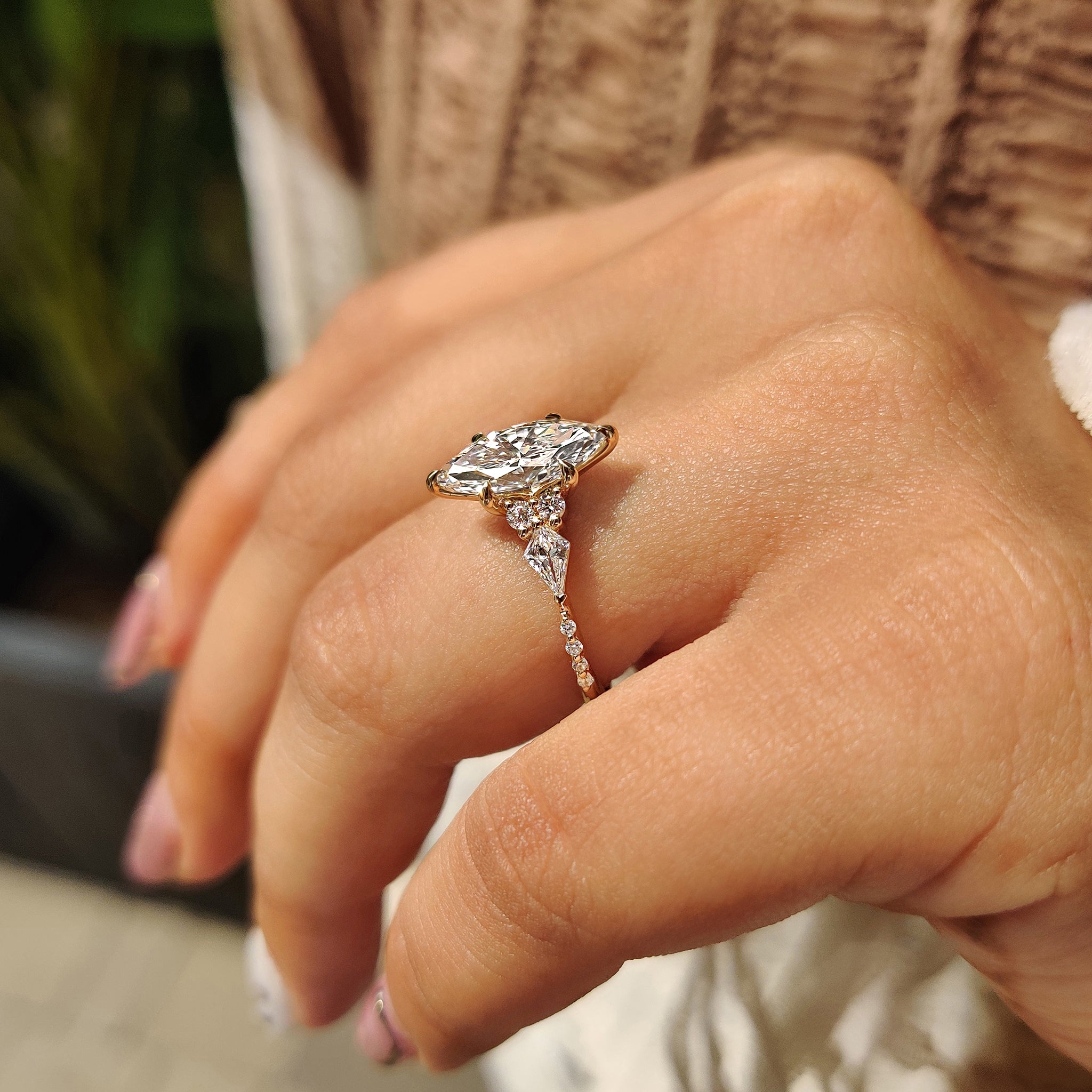 Marquise cut engagement ring with kite and round side stone.
