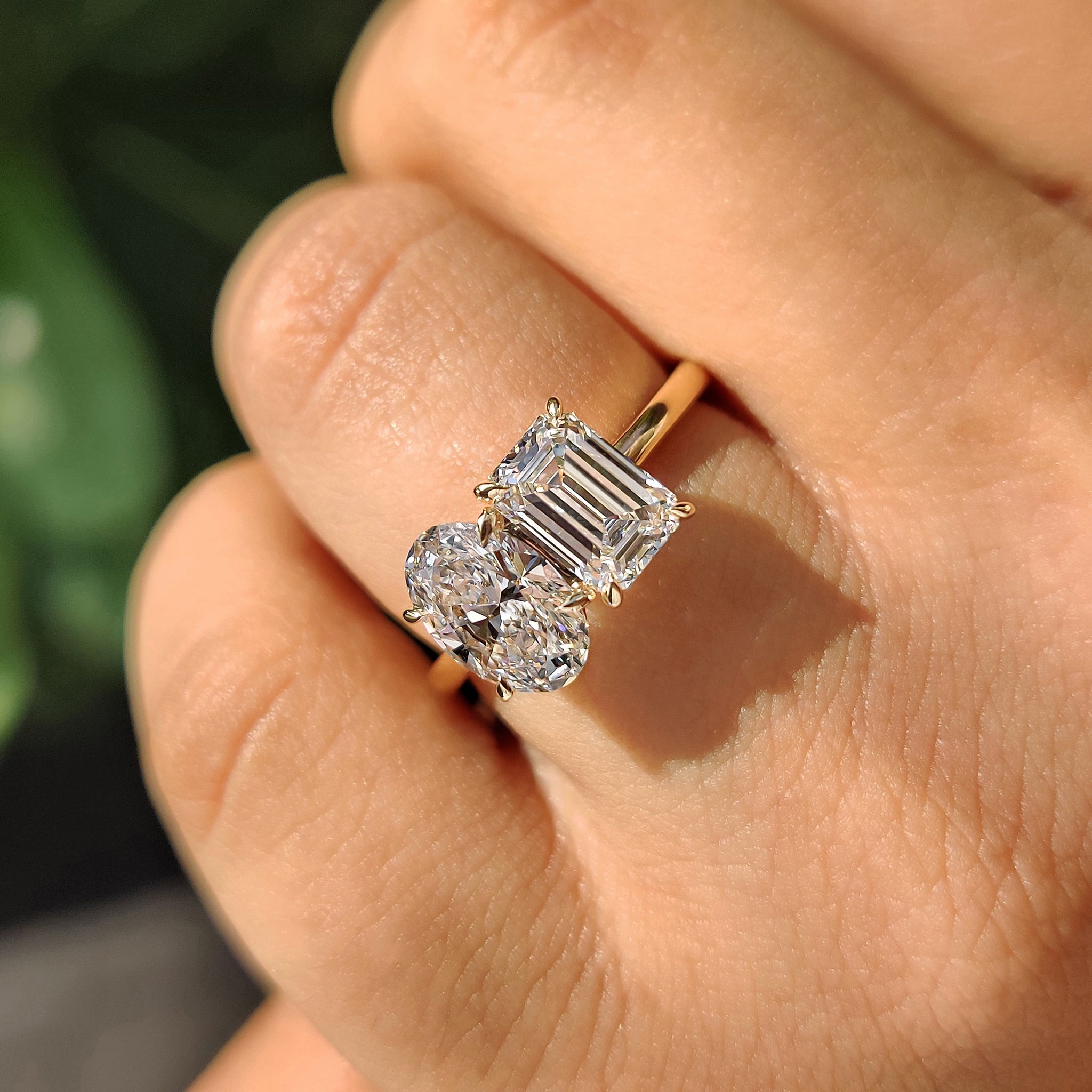 Oval emerald engagement ring with claw prong setting.
