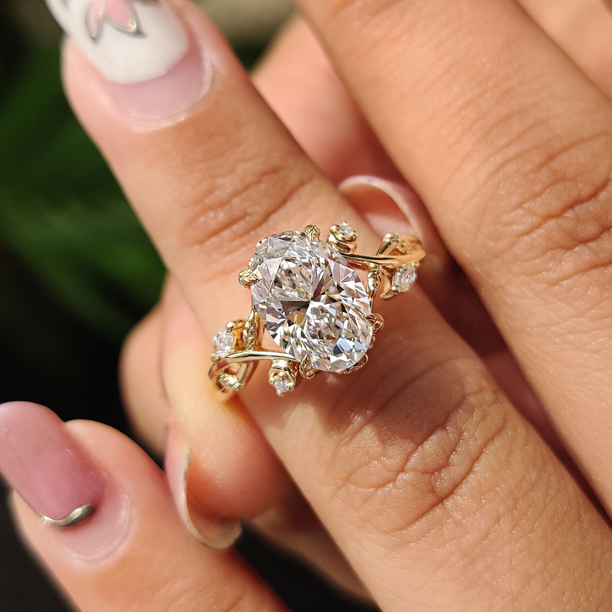 Cluster diamond engagement ring with marquise and round side stone.
