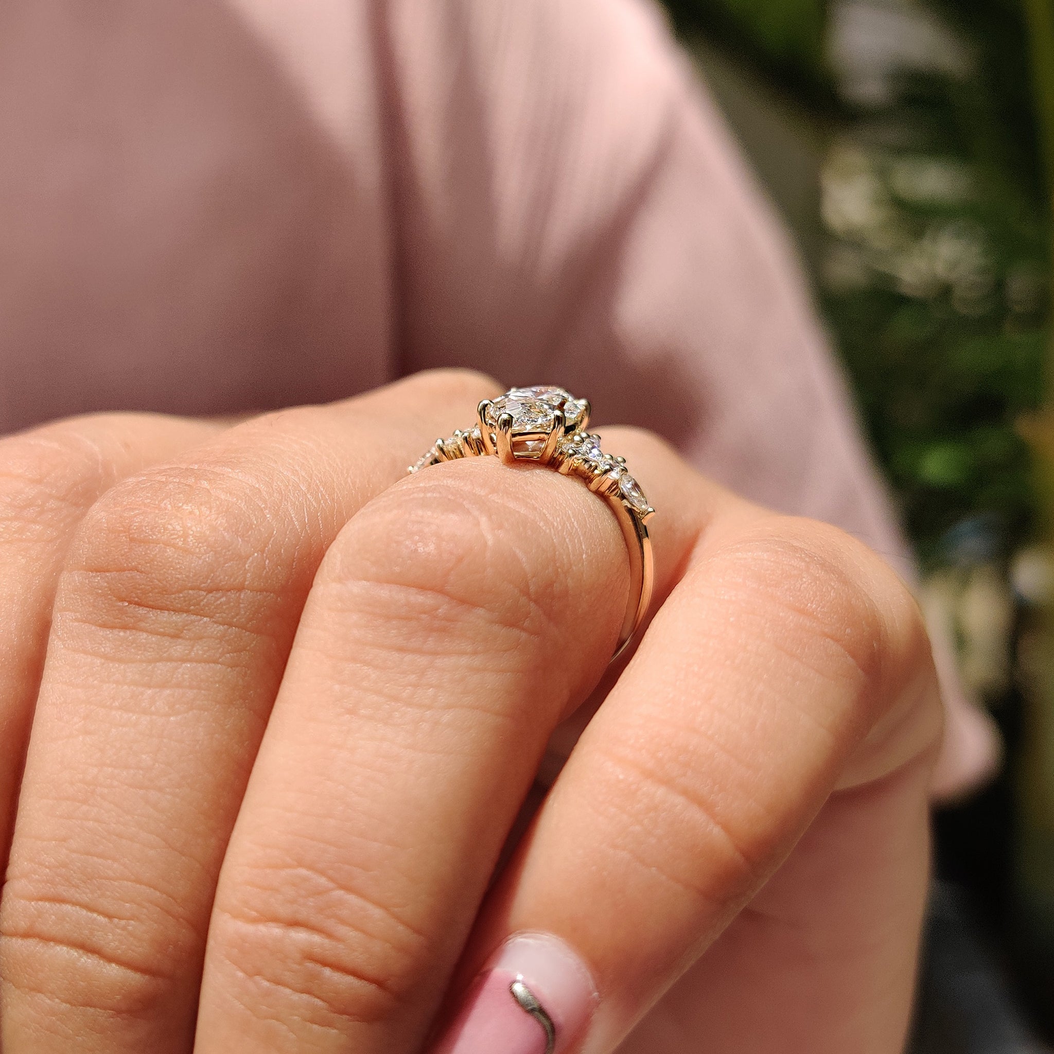 Cluster engagement ring with pear and round cut stone.