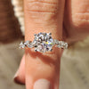 Round cut engagement ring with marquise side stone.