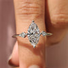 Marquise diamond engagement ring with round cut side stone.