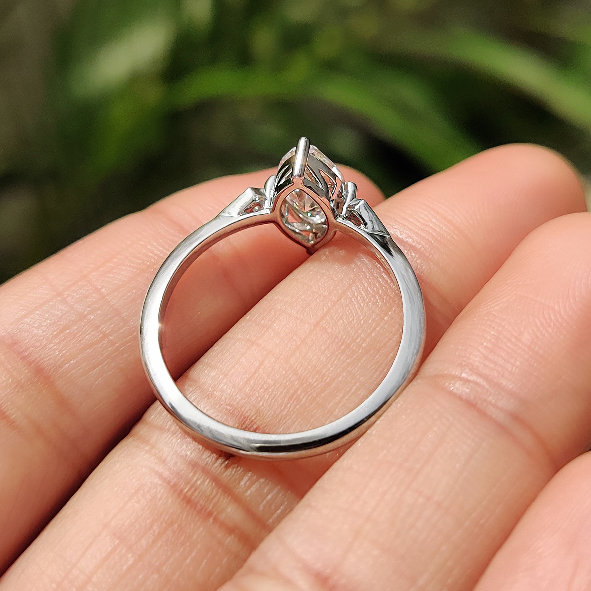 Round cut side stone with kite shape outline ring.