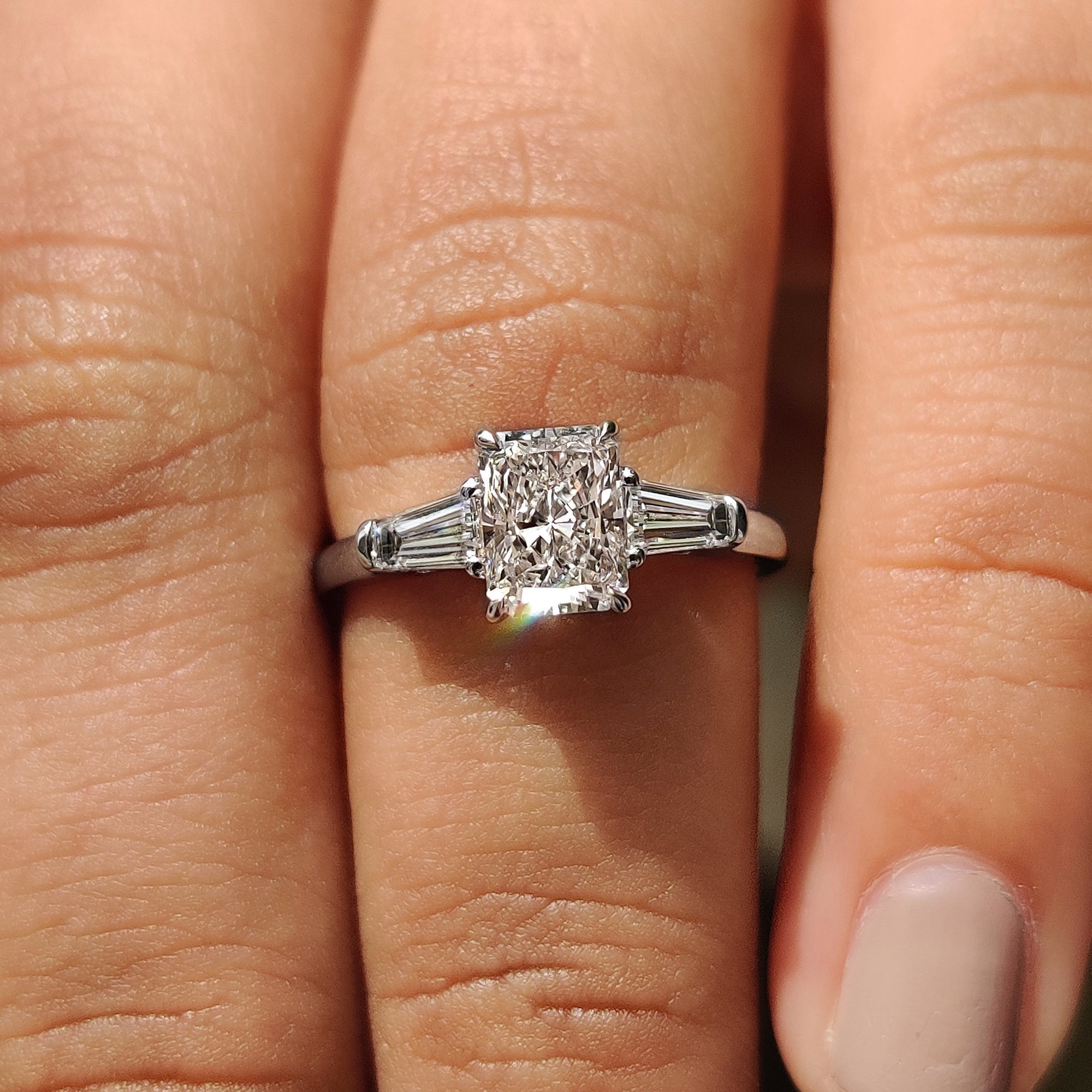 3 stone diamond engagement ring with tapered baguette side stone.
