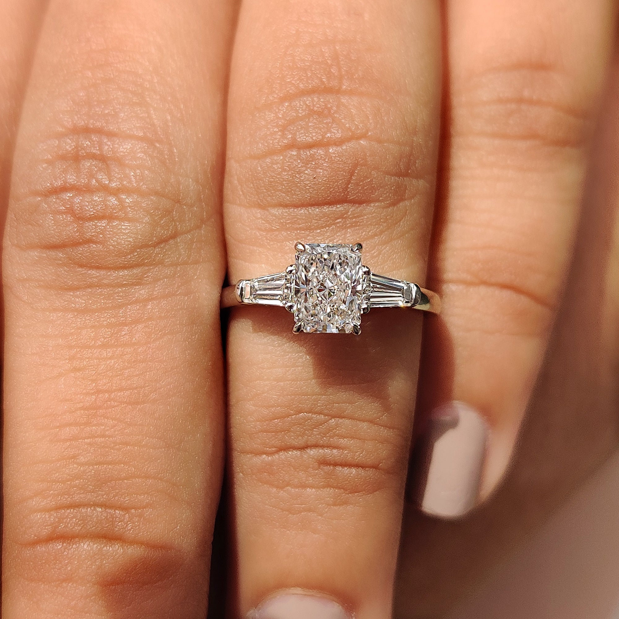 3 stone diamond engagement ring with tapered baguette side stone.