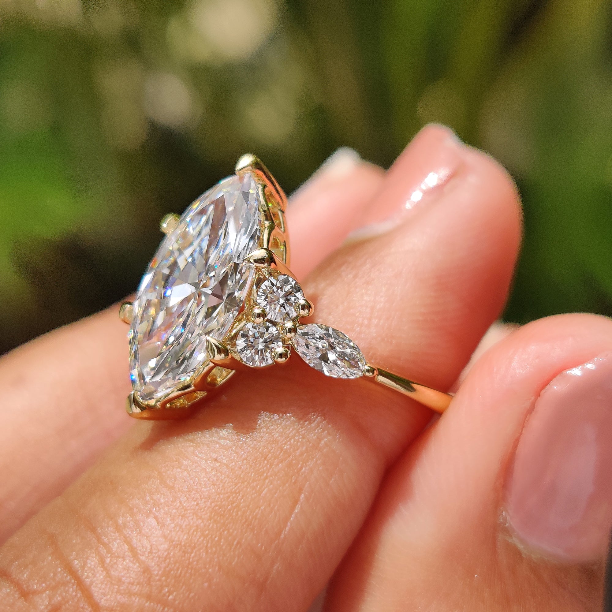 Marquise and round side stone with yellow gold engagement ring.
