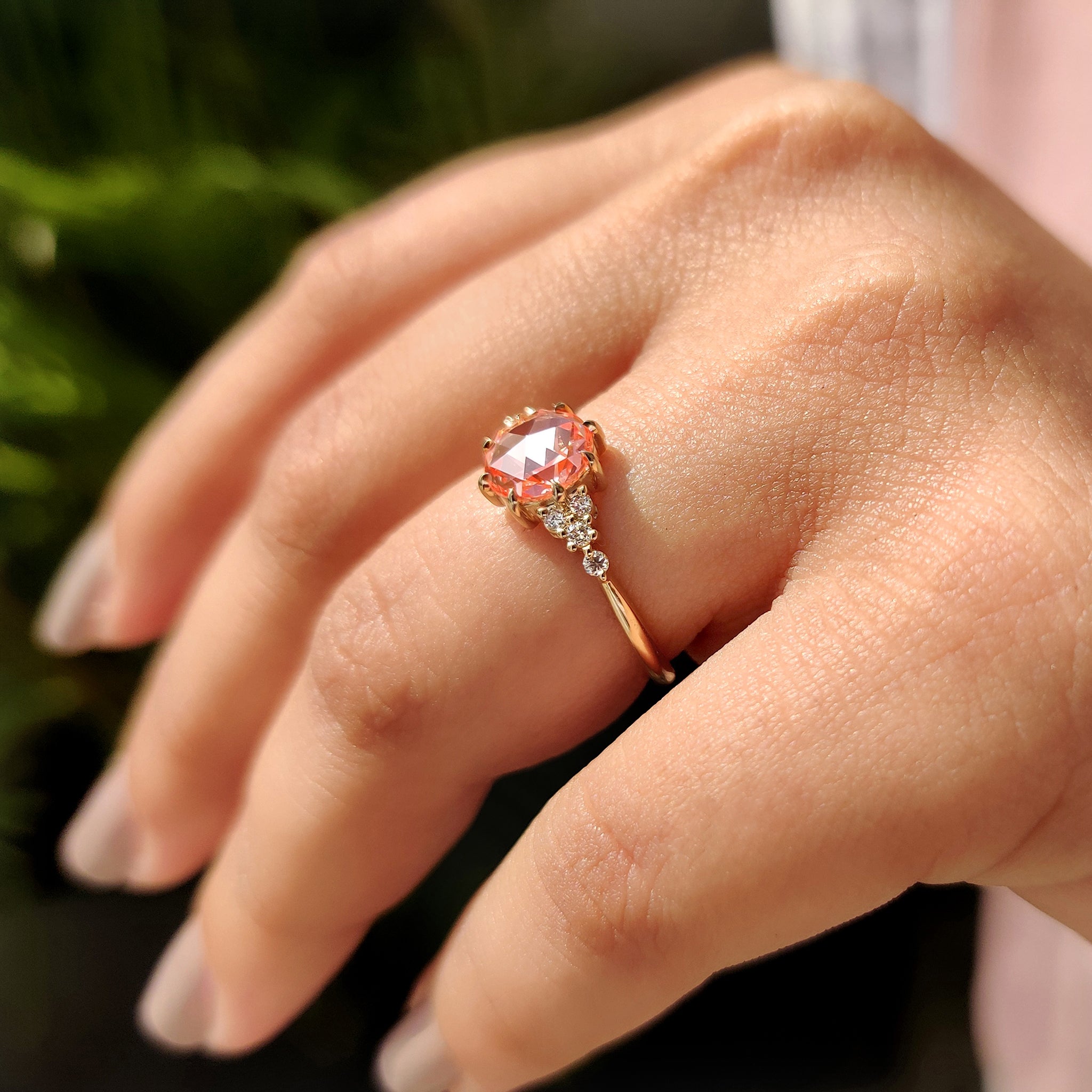 Pink diamond engagement ring with round cut side stone.