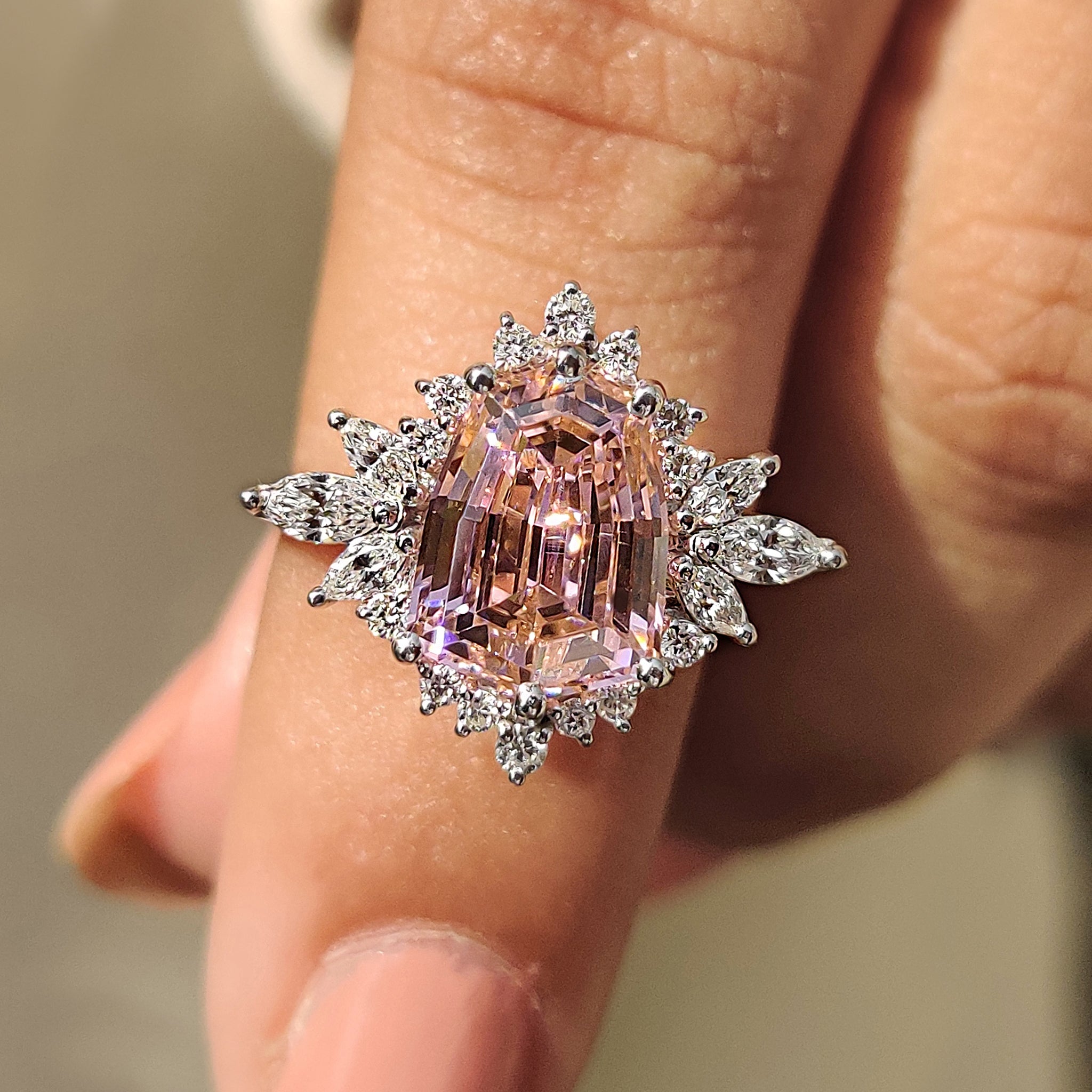 Pink gemstone ring with marquise and round side stone.