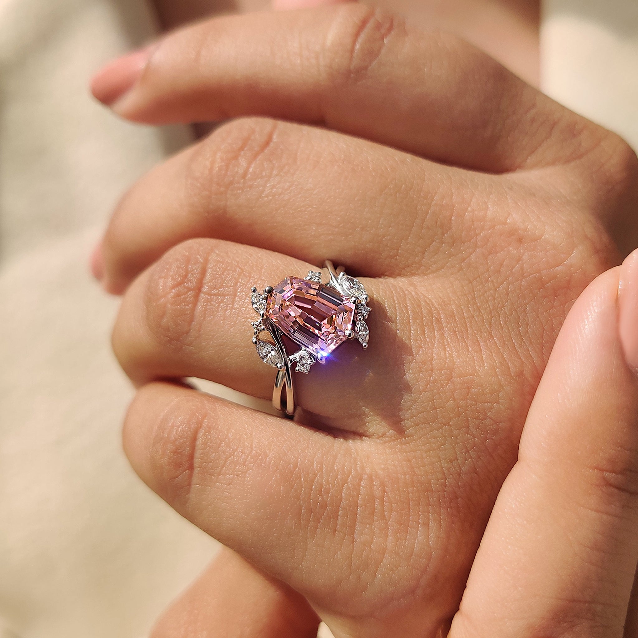 Shield cut engagement ring with marquise and round side stones.