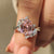 Bypass engagement ring with pink gemstone design.