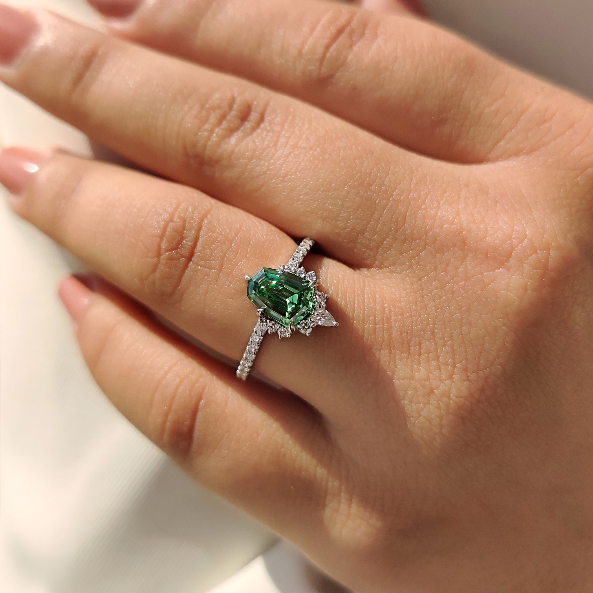 Half halo engagement ring with pear and round side stone.