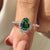 Green gemstone ring with shield cut engagement ring.